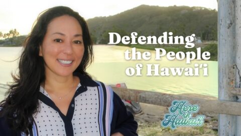 A woman smiling by a field with text "defending the people of Hawaii"