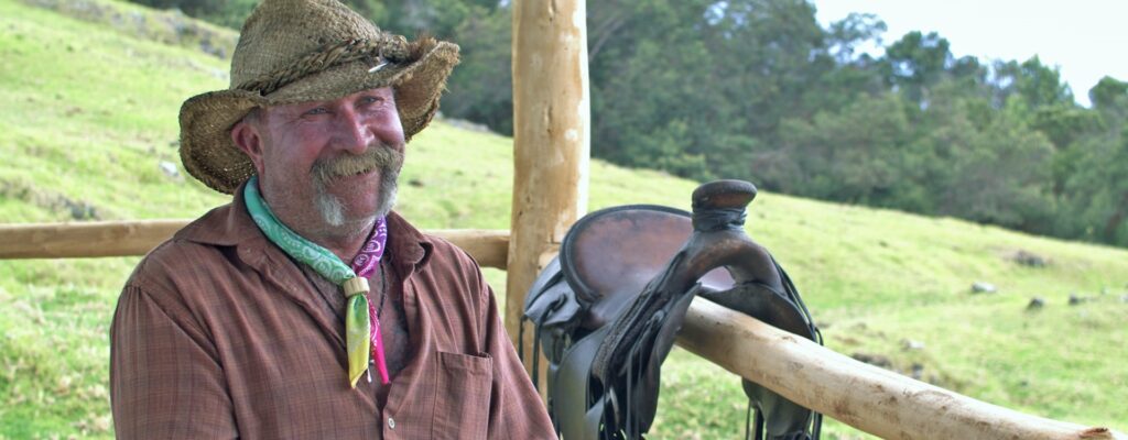 Man wearing a cowboy hat, smiling